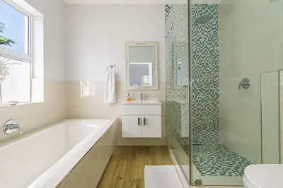 a bathroom with a tub and a shower and a sink at Irene Avenue Apartment with sea views in Somerset West