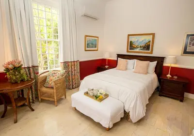 a bedroom with a bed and a table and a chair at Hotel du Vin Franschhoek in Franschhoek