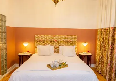 a bedroom with a large white bed with two lamps at Hotel du Vin Franschhoek in Franschhoek