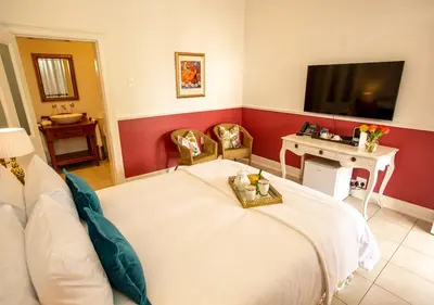 a bedroom with a white bed and a tv at Hotel du Vin Franschhoek in Franschhoek