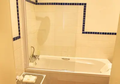 a bathroom with a bath tub with a sink at Hotel du Vin Franschhoek in Franschhoek