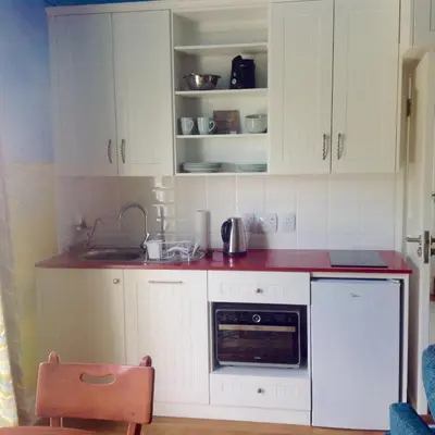 a kitchen with white cabinets and a red counter top at Little Farm in Raithby