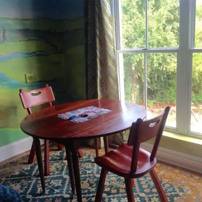 a wooden table and two chairs in front of a window at Little Farm in Raithby