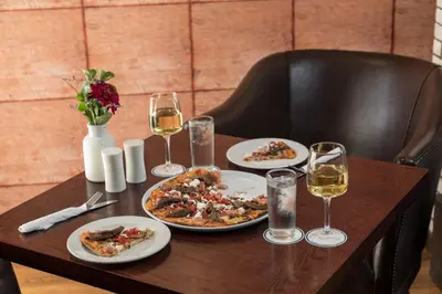 a table with plates of food and glasses of wine at Protea Hotel by Marriott Cape Town Durbanville in Bellville