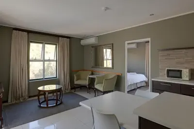 a hotel room with a kitchen and a bedroom at Protea Hotel by Marriott Cape Town Durbanville in Bellville