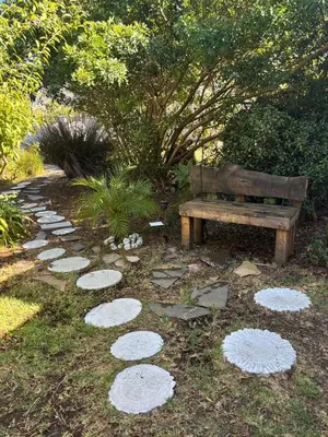 a bench and a path with stepping stones and a park at Self Catering Unit , Sandbaai in Hermanus