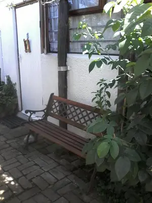 a wooden bench sitting in front of a building at Self Catering Unit , Sandbaai in Hermanus