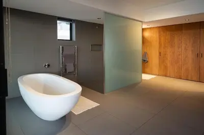 a bathroom with a large white tub and a shower at '22 Protea' - Luxury, Style and Elegance - Sleeps 12 in 6 En-suite Bedrooms in Gordonʼs Bay