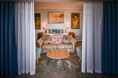a hotel room with a bed and a couch at Die Badhuis, for Fabulous living! Sleeps 4, Private pool in Gordonʼs Bay