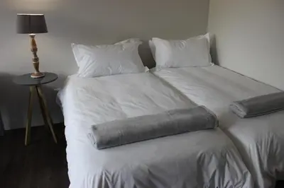 a bed with two pillows on top of it at Zeederberg Corner in Paarl