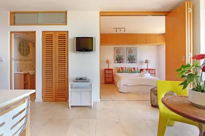 a room with a bedroom with a bed and a table at Neptune Isle 214 in Cape Town