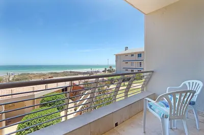 a balcony with two chairs and a view of the beach at Neptune Isle 214 in Cape Town