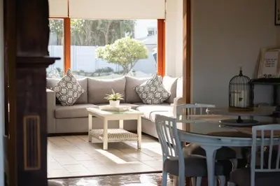 a living room with a couch and a table at Normandie On Sea in Hermanus