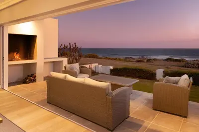 a living room with a view of the ocean at Seapearl Oceanfront Villa and Cottage in Hermanus