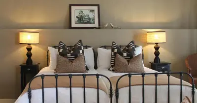 a bedroom with two beds with pillows and two lamps at Mount Grace Country House in Greyton
