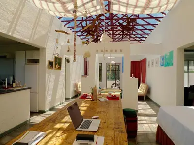 a living room with a laptop on a wooden table at Sky house on Clarens in Bettyʼs Bay