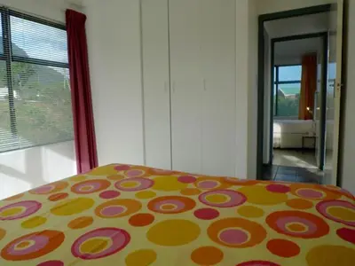 a bedroom with a bed with a colorful comforter at Sky house on Clarens in Bettyʼs Bay