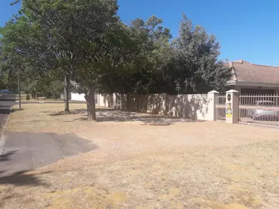 a tree in a yard next to a fence at Cottage@Somerset in Somerset West