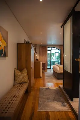 a living room with a couch and a bedroom at Le Petit Manoir Boutique Hotel in Franschhoek