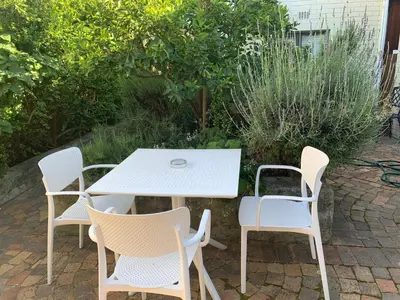 a white table and chairs on a patio at Courtyard Studio lights and wi fi during load shedding in Stellenbosch