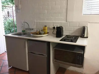 a kitchen counter with a sink and a microwave at Courtyard Studio lights and wi fi during load shedding in Stellenbosch