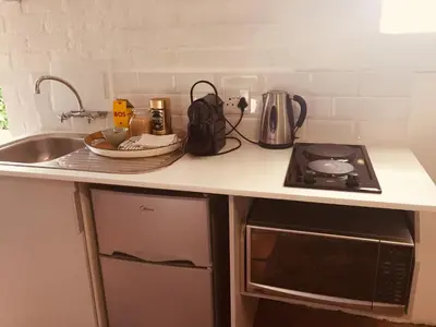 a kitchen counter with a stove and a sink at Courtyard Studio lights and wi fi during load shedding in Stellenbosch