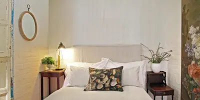 a bedroom with a bed with two pillows on it at Courtyard Studio lights and wi fi during load shedding in Stellenbosch