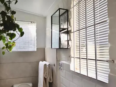 a bathroom with a toilet and a window at Courtyard Studio lights and wi fi during load shedding in Stellenbosch