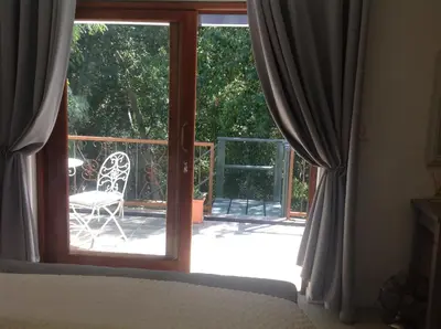 a bedroom with a bed and a sliding glass door at Willow Brooke Guest Suite in Franschhoek