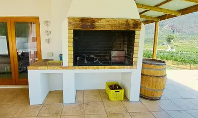 a fireplace in a living room with a barrel at Mountainview Vineyards in Robertson