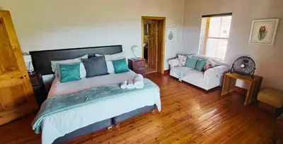 a bedroom with a large bed and a couch at Mountainview Vineyards in Robertson