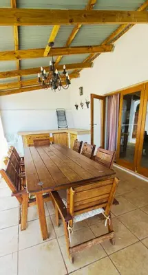 a wooden dining room table with chairs and a chandelier at Mountainview Vineyards in Robertson