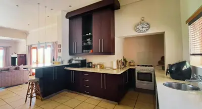 a kitchen with wooden cabinets and a clock on the wall at Mountainview Vineyards in Robertson