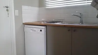 a kitchen with a sink and a dishwasher at Corban Cottage in Hermanus