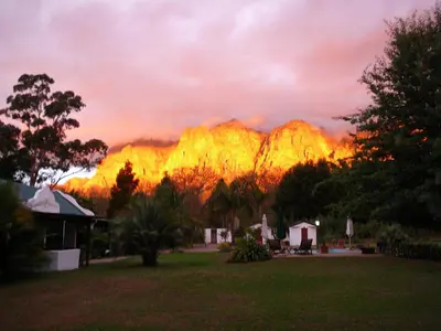 a view of a mountain range with a sunset at Orange-Ville Lodge & Guesthouse in Stellenbosch