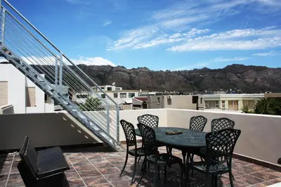 a patio with a table and chairs on a balcony at 20 Cayman Beach, Gordon's Bay in Gordonʼs Bay