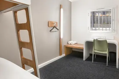 a small room with a desk and a window at SUN1 MILNERTON in Cape Town