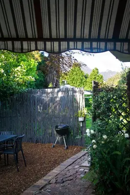 a patio with a grill and a fence at Olive tree private rooms in Stellenbosch- No Load Shedding in Stellenbosch
