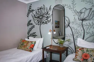 a room with two beds and a mirror and a table at Olive tree private rooms in Stellenbosch- No Load Shedding in Stellenbosch