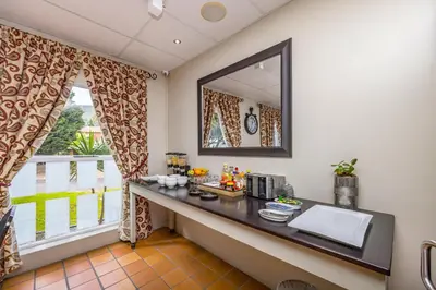 a room with a table with a mirror and a window at Plattekloof Premium Lodge in Plattekloof