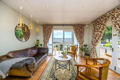 a living room with a leather couch and a table at Plattekloof Premium Lodge in Plattekloof