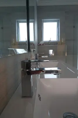 a white bathroom with a sink and two windows at Hamilton Garden Suites in Parklands