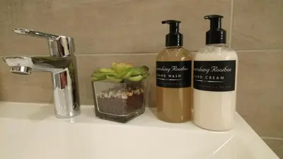 two bottles ofodorizers sitting on a bathroom sink at Hamilton Garden Suites in Parklands