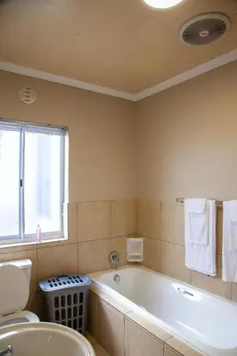 a bathroom with a tub and a toilet and a sink at 80 Kendal Self-Catering Guest House in Bellville