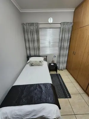 a small bedroom with a bed and a window at 80 Kendal Self-Catering Guest House in Bellville