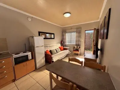a kitchen and living room with a refrigerator and a table at 80 Kendal Self-Catering Guest House in Bellville