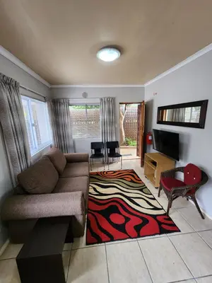 a living room with a couch and a rug at 80 Kendal Self-Catering Guest House in Bellville