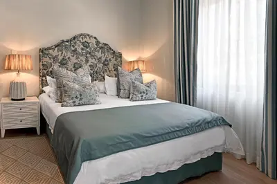 a bedroom with a large bed and a window at The Coach House in Franschhoek
