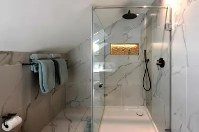 a bathroom with a shower with a glass door at The Coach House in Franschhoek