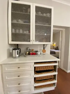a kitchen with white cabinets and a counter at Olive and Vine Farm Cottage in Franschhoek